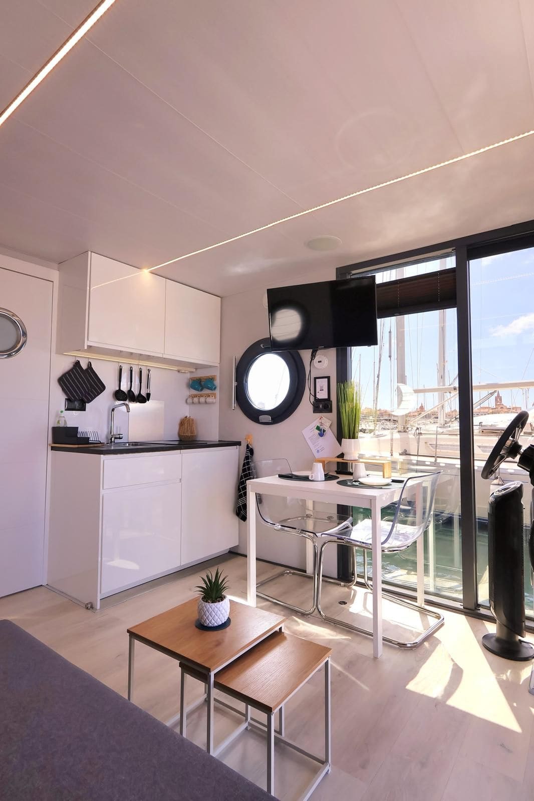 Luce del mattino nel soggiorno, con la vetrata aperta sul porto