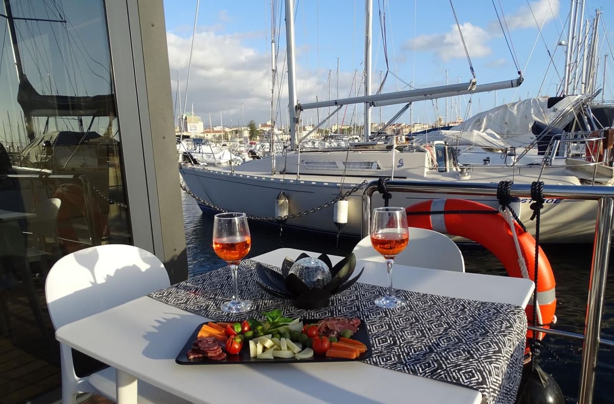 Due calici di spritz e un tagliere sulla terrazza, accanto alle barche a vela